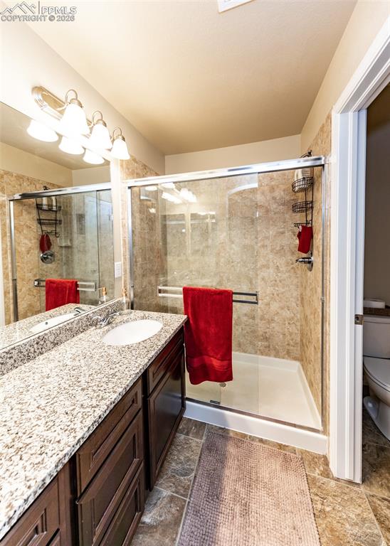 Image 30 of 32: Bathroom with vanity and a stall shower