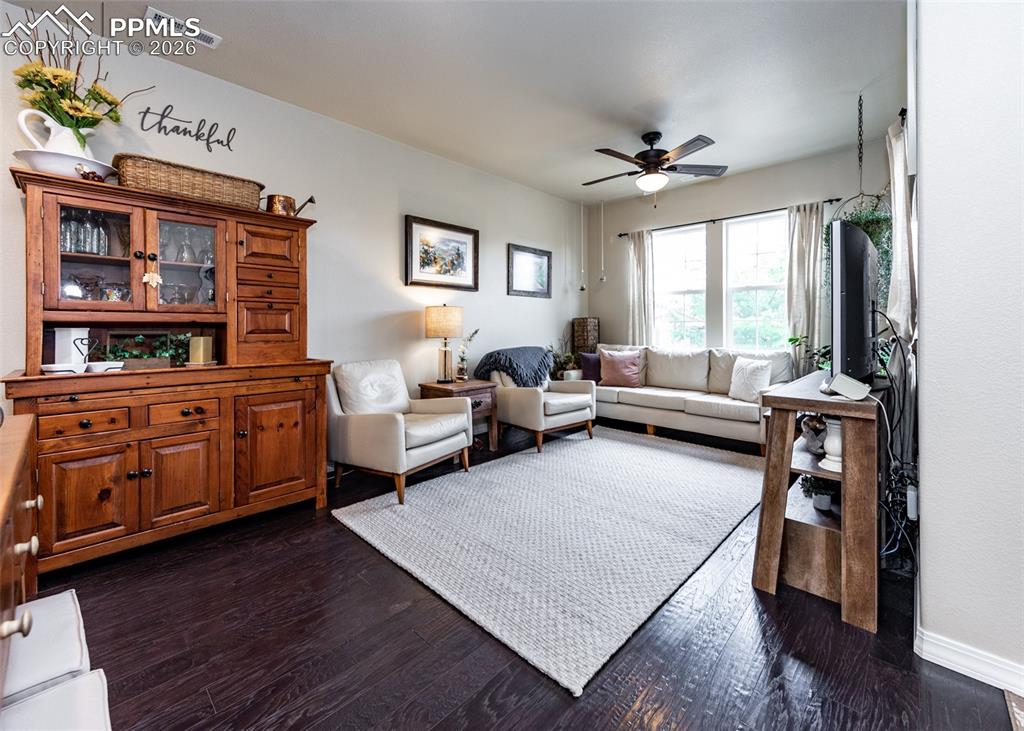 Image 4 of 32: Living room featuring dark wood finished floors and a ceiling fan