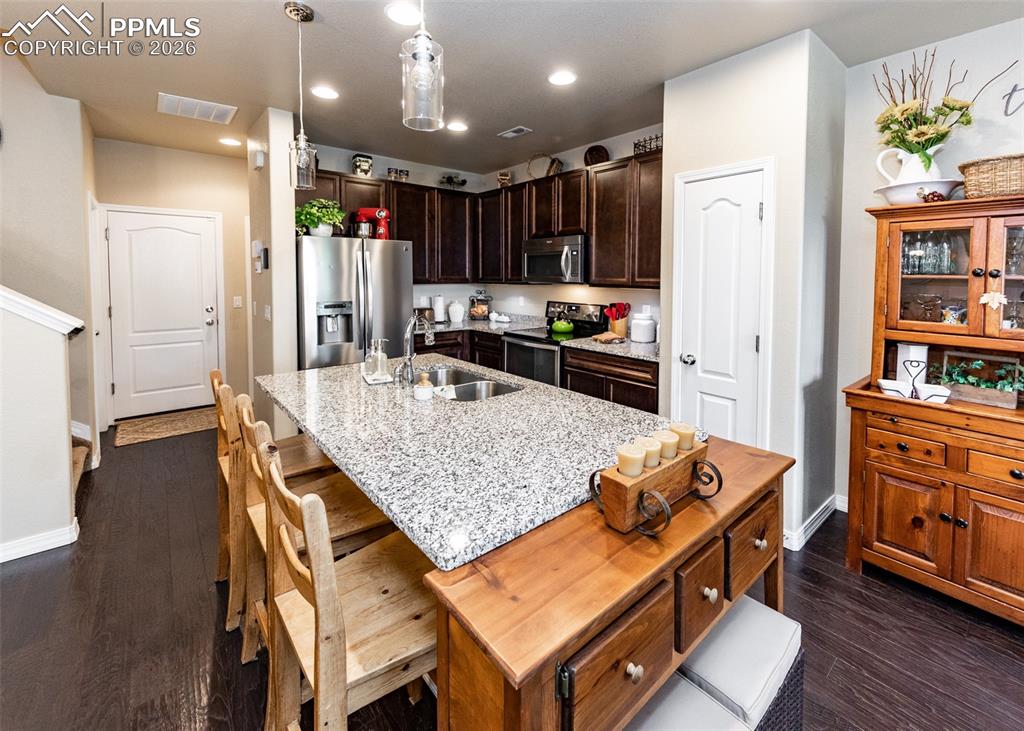 Image 9 of 32: Kitchen with hanging light fixtures, stainless steel appliances, recessed l