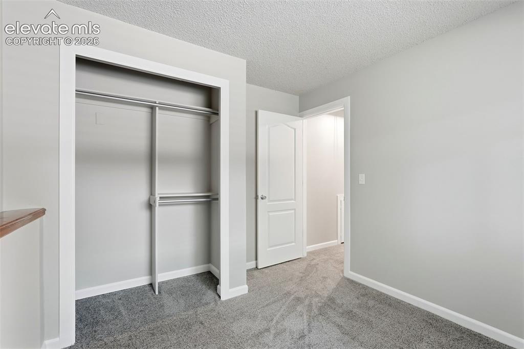 Image 20 of 35: Room featuring light gray walls, gray carpet flooring, white baseboards, an