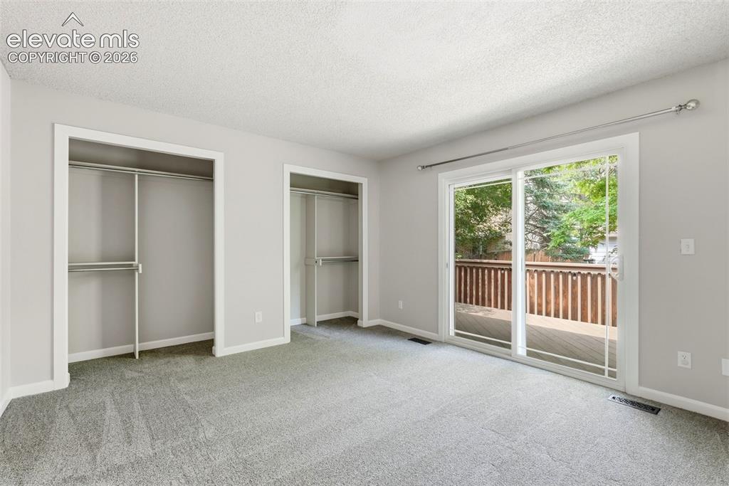 Image 21 of 35: Room featuring light gray carpet, dual open closets with shelving and hangi