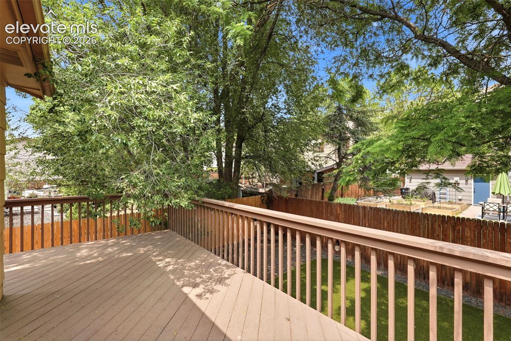 Image 27 of 35: Expansive outdoor deck featuring wood-finish flooring and a matching railin