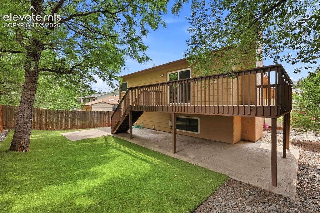 Image 30 of 35: Exterior featuring a raised deck with stairs, lower-level concrete patio, a