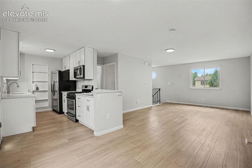 Image 10 of 27: Spacious room featuring light wood-finish flooring, neutral wall tones, rec