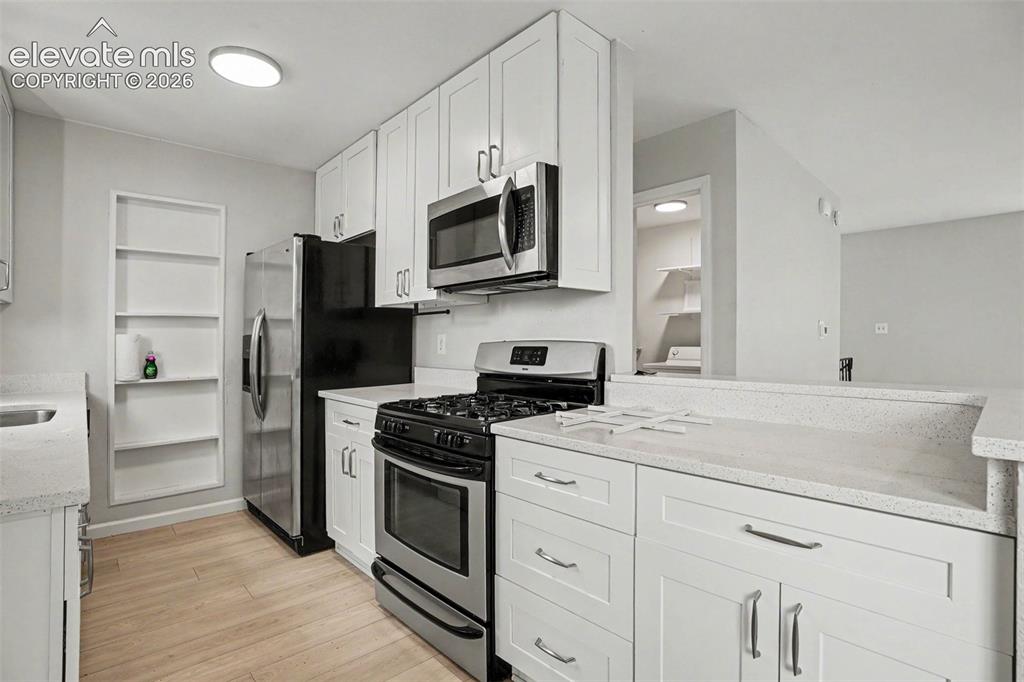 Image 11 of 27: Spacious room featuring light wood-finish flooring, white baseboards, and n
