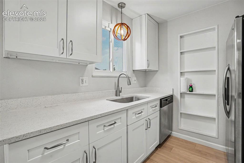 Image 14 of 27: Open-concept living area featuring wood-finish flooring, recessed lighting,