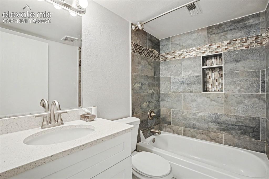 Image 18 of 27: Kitchen featuring white shaker-style cabinetry, light speckled countertops,