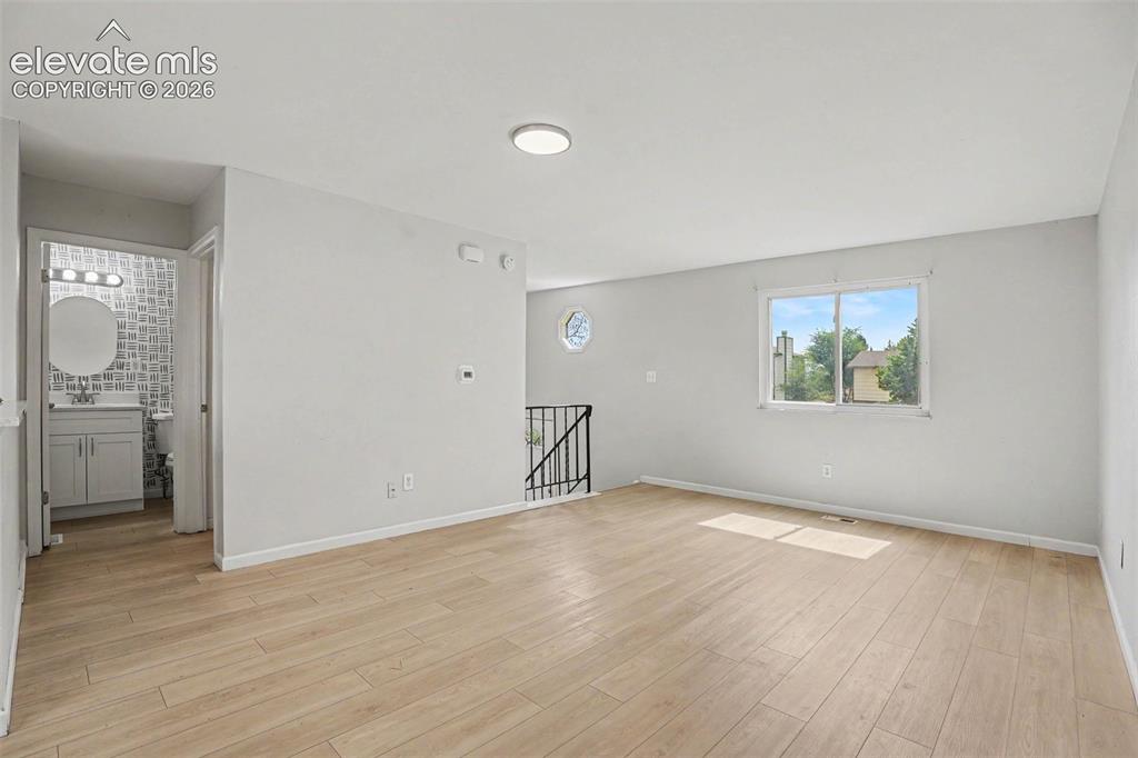 Image 8 of 27: Carpeted staircase with dark metal handrails and white wall finishes