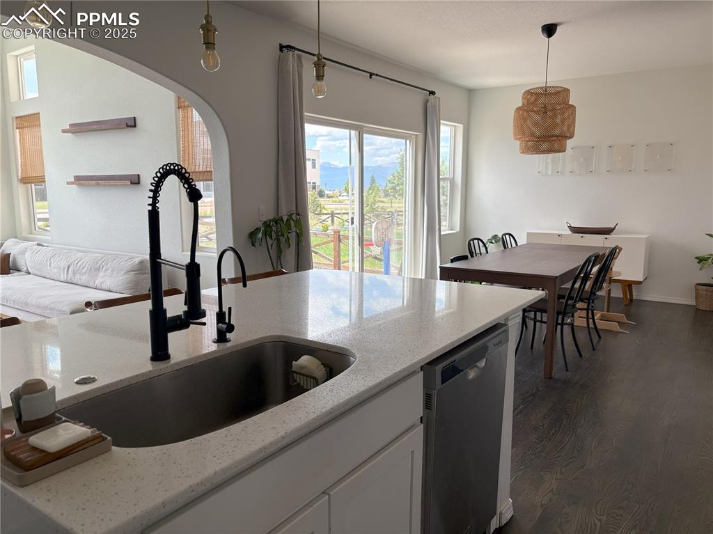 Image 9 of 35: Kitchen with arched walkways, dishwashing machine, dark wood-style flooring