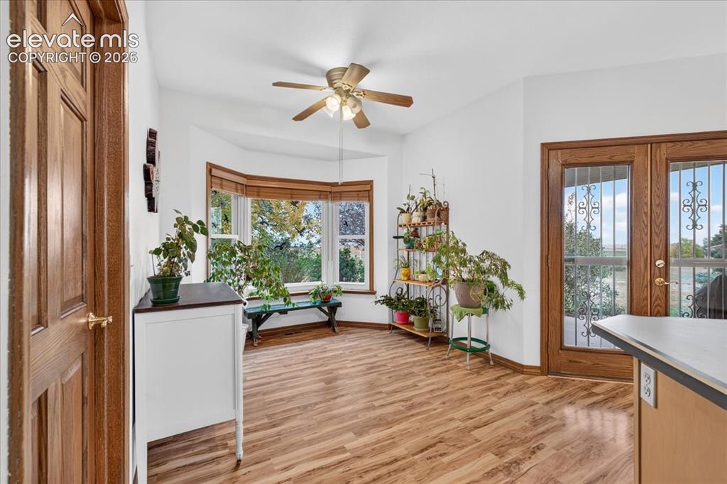 Image 12 of 44: Bay window with natural light, wood-finish flooring, multi-pane glass door