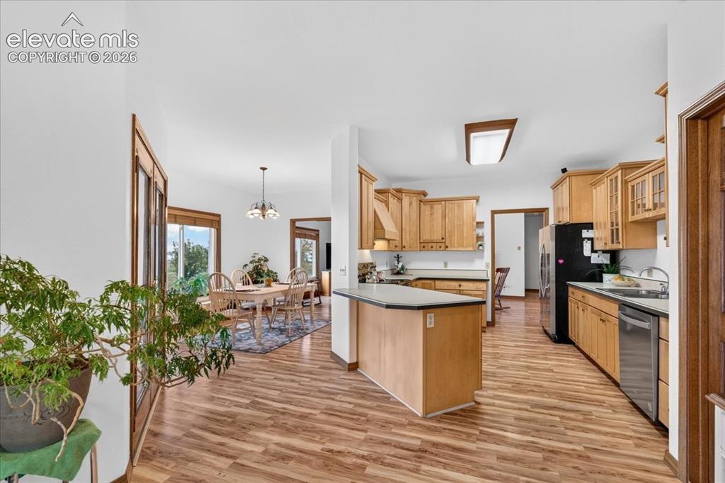 Image 13 of 44: Kitchen featuring wood cabinetry, a center island with a solid surface coun