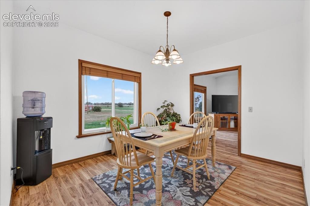 Image 14 of 44: Dining area featuring wood-finish flooring, a multi-light chandelier, and l