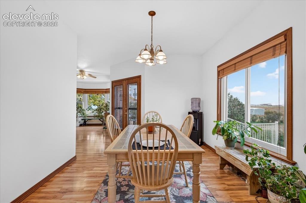 Image 15 of 44: Dining area featuring wood-finish flooring, a multi-light chandelier, expan