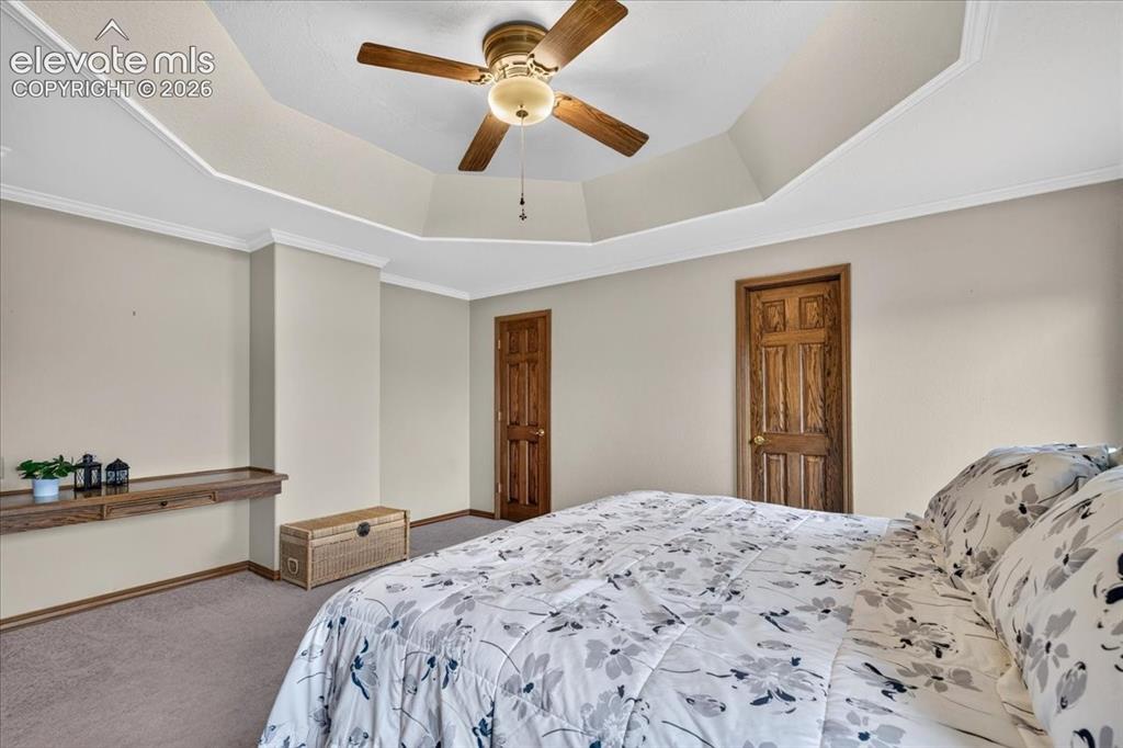 Image 17 of 44: Tray ceiling featuring a central ceiling fan with integrated lighting, buil