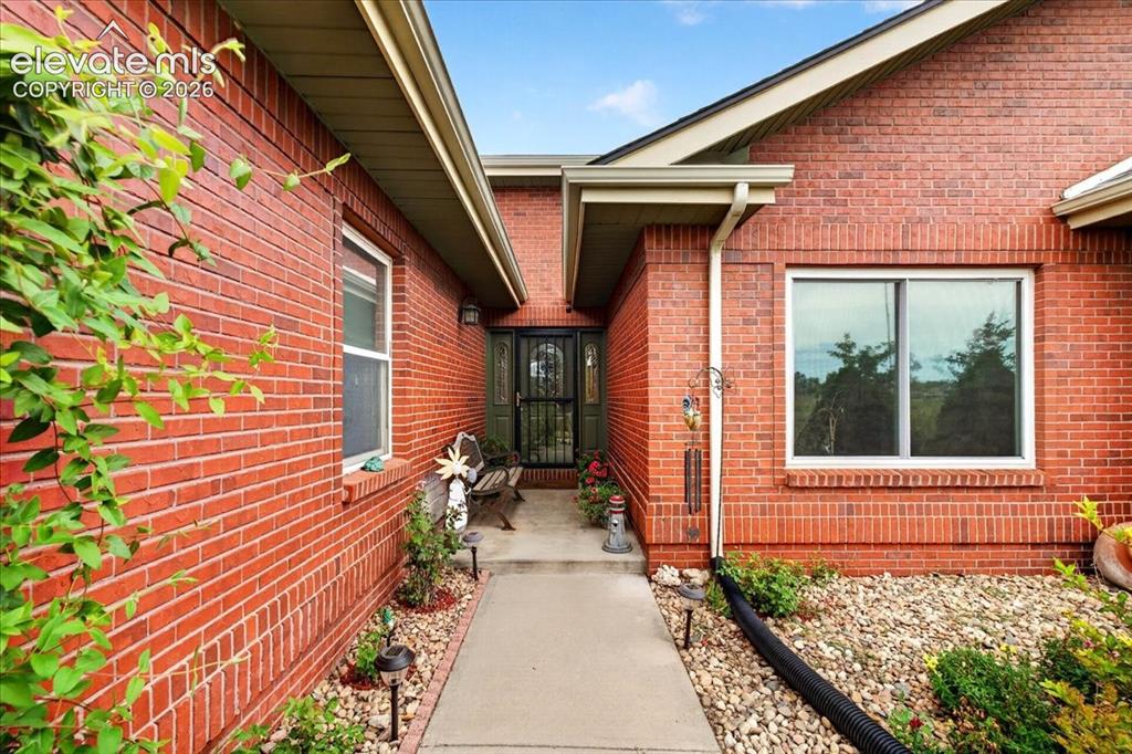 Image 2 of 44: Brick exterior featuring a recessed entryway, concrete walkway, and double-