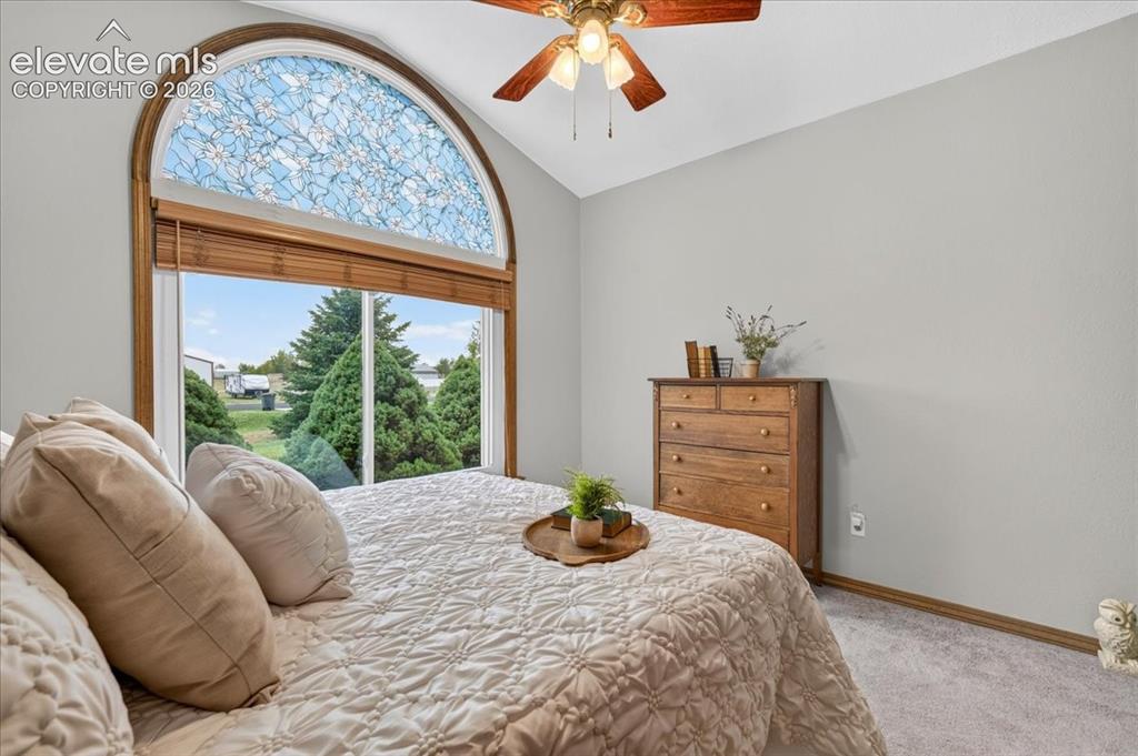 Image 21 of 44: Vaulted ceiling featuring an arched window with decorative leaded glass, ne