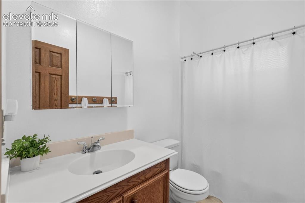 Image 22 of 44: Bathroom featuring a wood-finish vanity with a white countertop and oval un