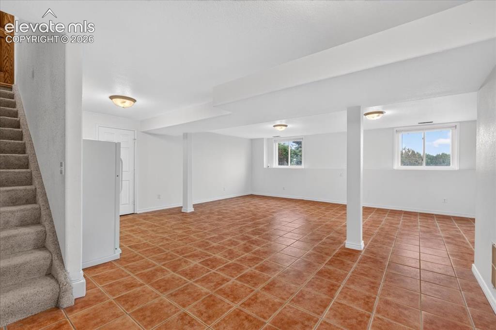 Image 25 of 44: Open-concept room featuring terra-cotta tile flooring, flush-mount ceiling 