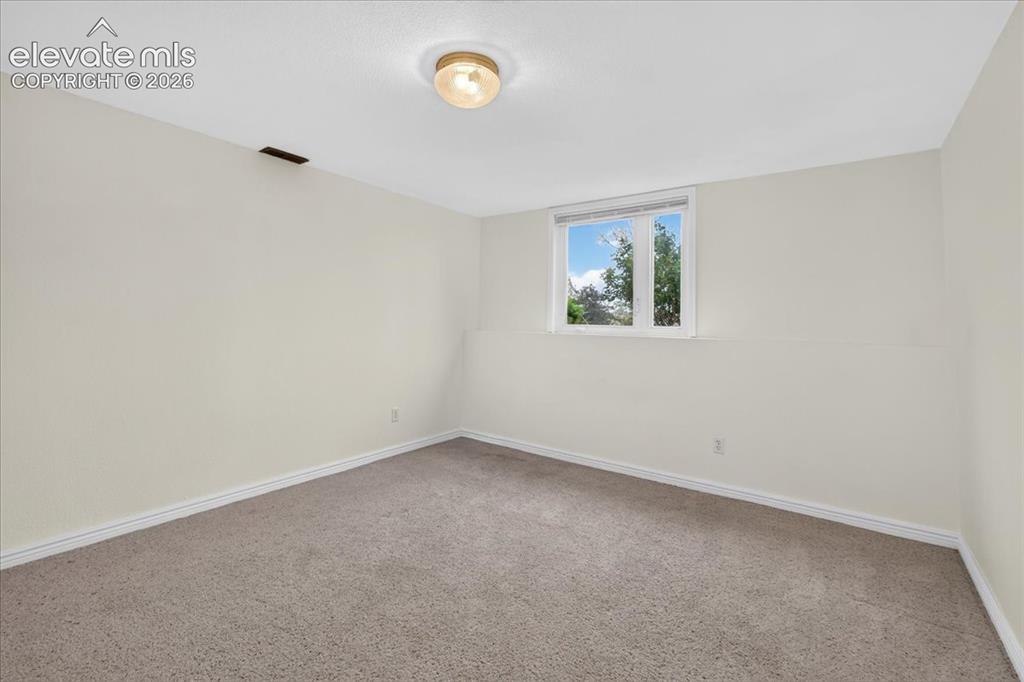 Image 27 of 44: Interior space featuring neutral-toned carpeting, light-colored walls, a si
