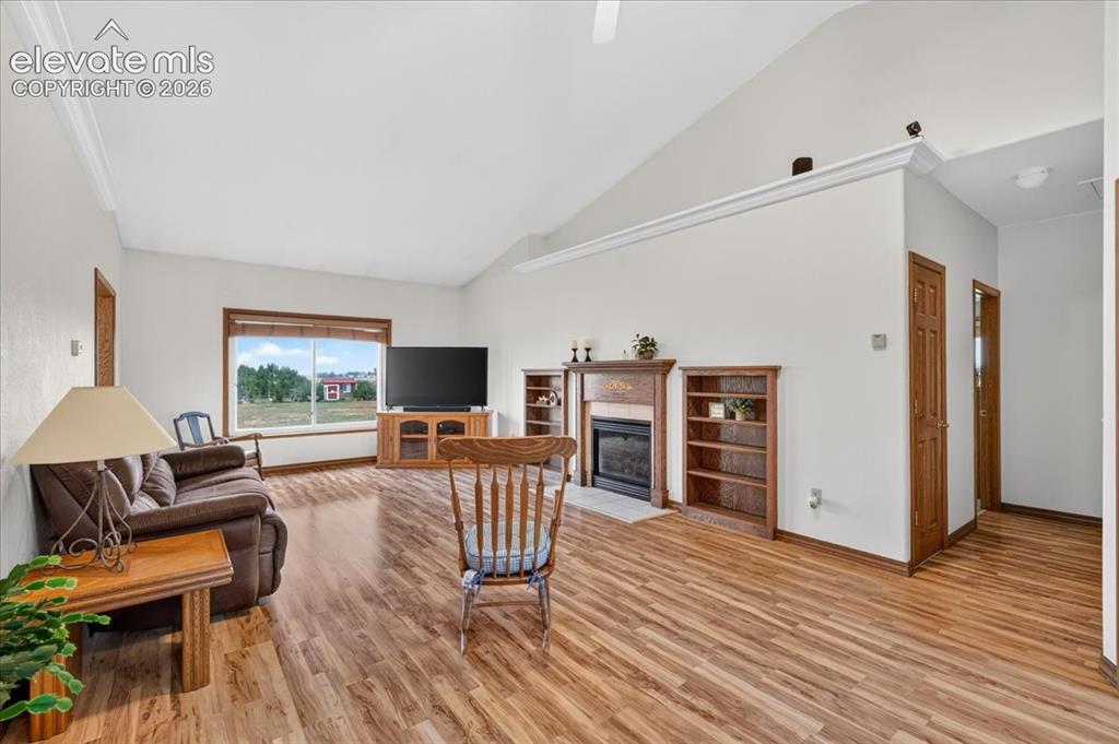 Image 3 of 44: Vaulted ceilings, wood-finish flooring, built-in wooden shelving, and a fir