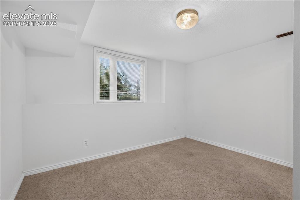 Image 30 of 44: Neutral-toned interior space featuring wall-to-wall carpeting, a recessed w