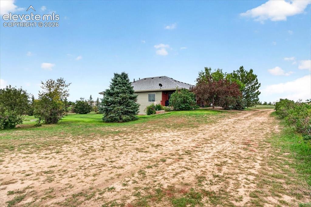 Image 31 of 44: Single-story residence featuring a hipped roof, neutral siding, expansive g