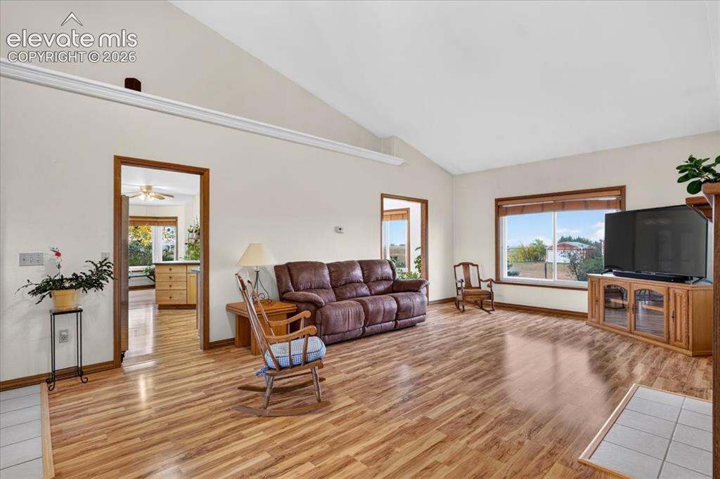 Image 4 of 44: Vaulted ceilings, wood-finish flooring, and large picture windows featuring