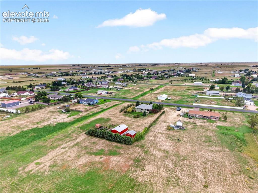 Image 43 of 44: Aerial perspective of expansive acreage featuring open pasture land, establ