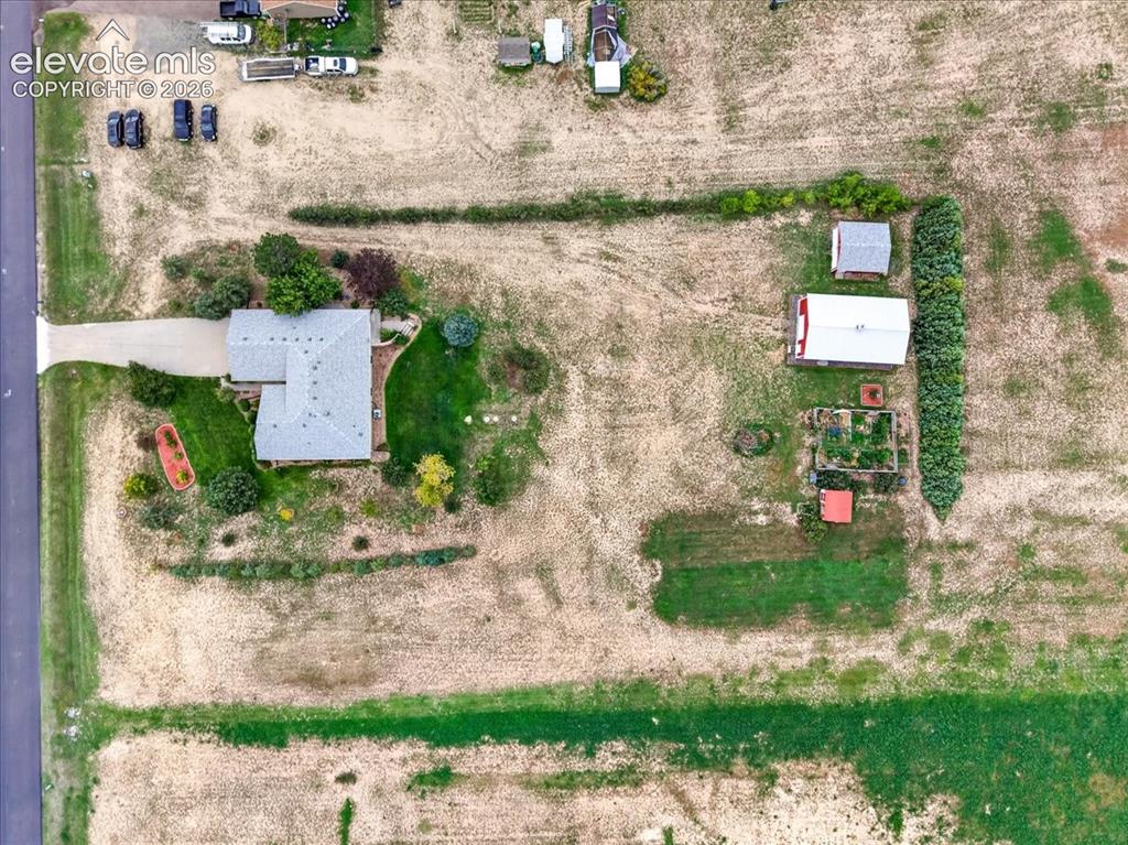Image 44 of 44: Aerial view of expansive lot featuring a single-story residence, detached g