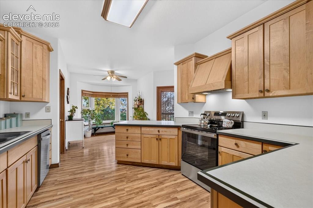 Image 7 of 44: Kitchen featuring natural wood cabinetry, stainless steel range, wood-finis