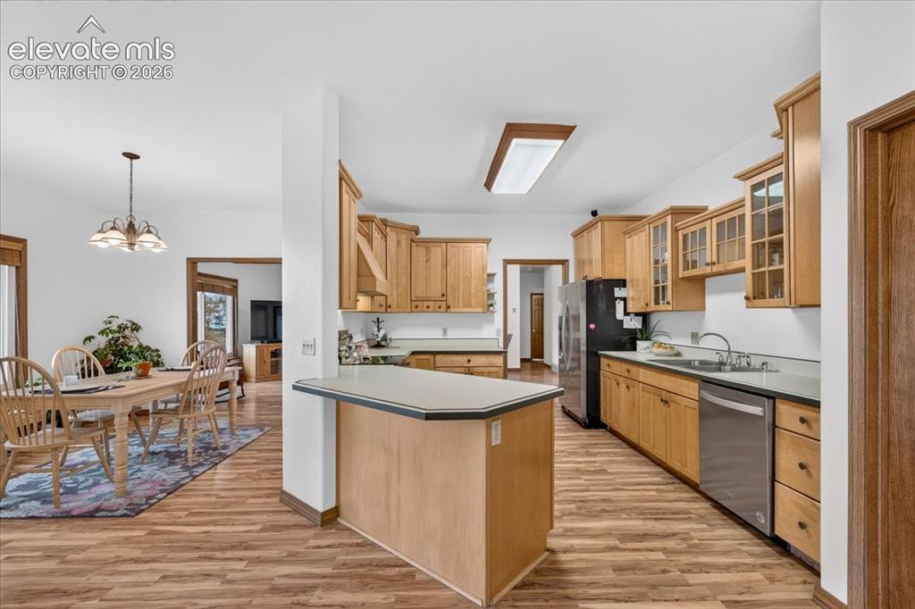 Image 9 of 44: Kitchen featuring natural wood cabinetry, a breakfast bar, solid surface co