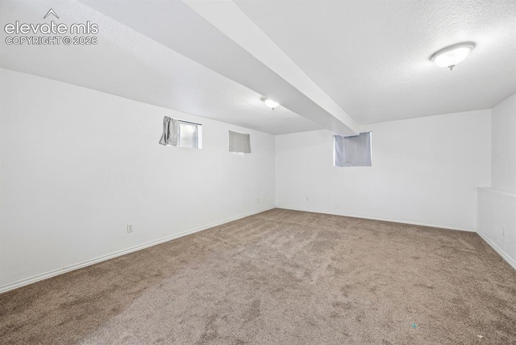 Image 11 of 20: Spacious room with plush carpeting, neutral white walls, and flush-mount ce