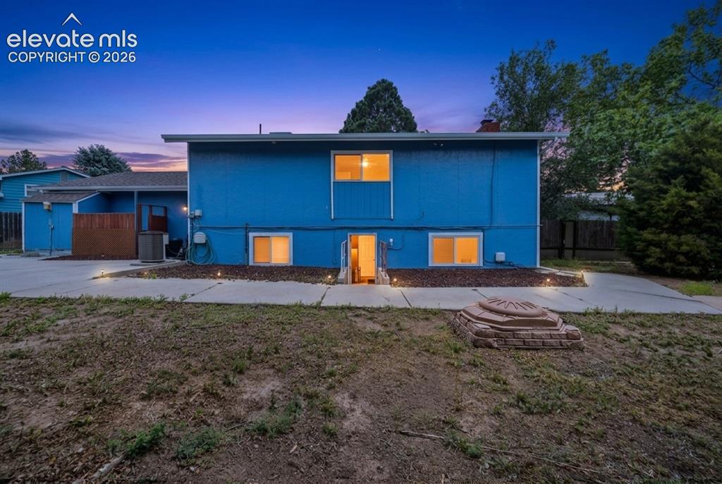 Image 18 of 20: Exterior featuring a vibrant blue facade, multiple windows, and a paved pat