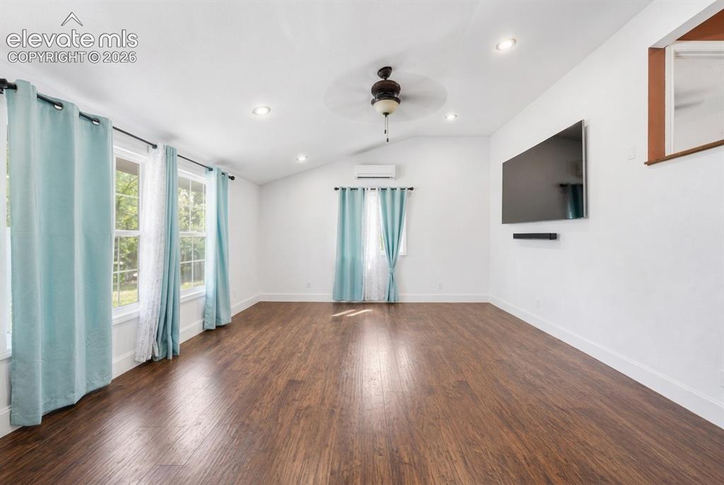 Image 3 of 20: Vaulted ceilings with recessed lighting, wood-finish flooring, and multiple