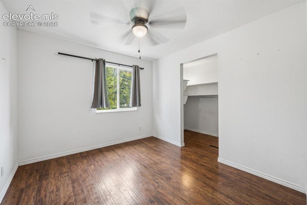 Image 9 of 20: Wood-finish flooring, white walls, and a ceiling fan