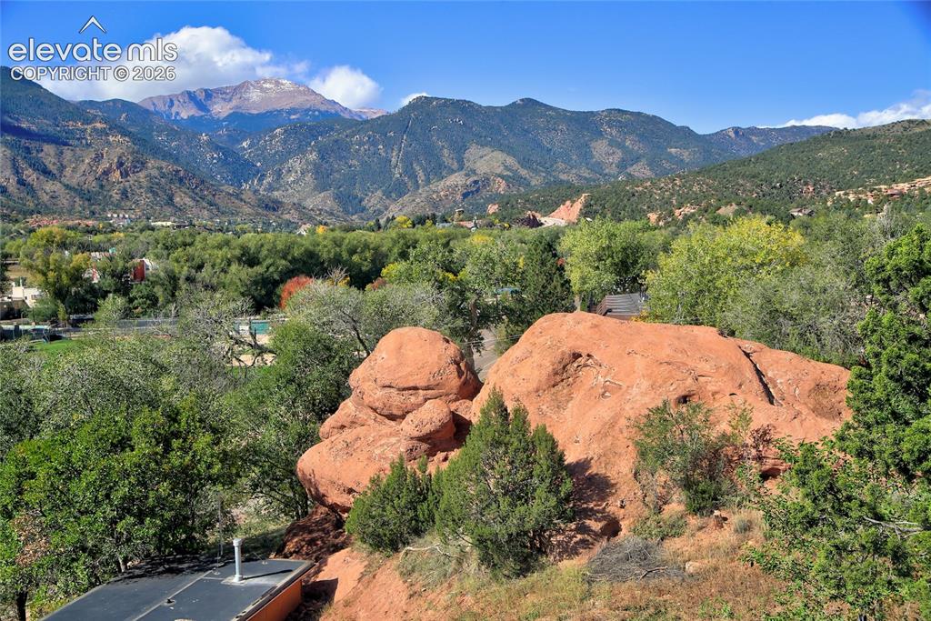 Image 10 of 26: Prominent red rock formations, mature deciduous and evergreen trees, and a