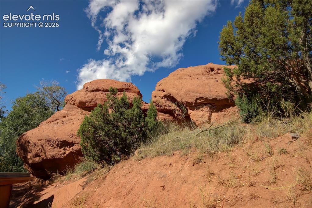 Image 12 of 26: Natural sandstone rock formations set against native evergreen vegetation a