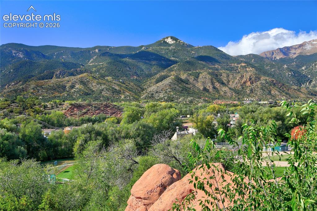 Image 4 of 26: Expansive mountain range backdrop featuring rugged natural rock formations,