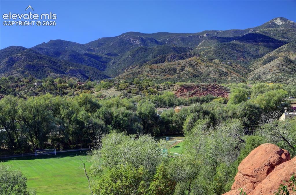 Image 6 of 26: Expansive mountain backdrop featuring prominent geological rock formations,