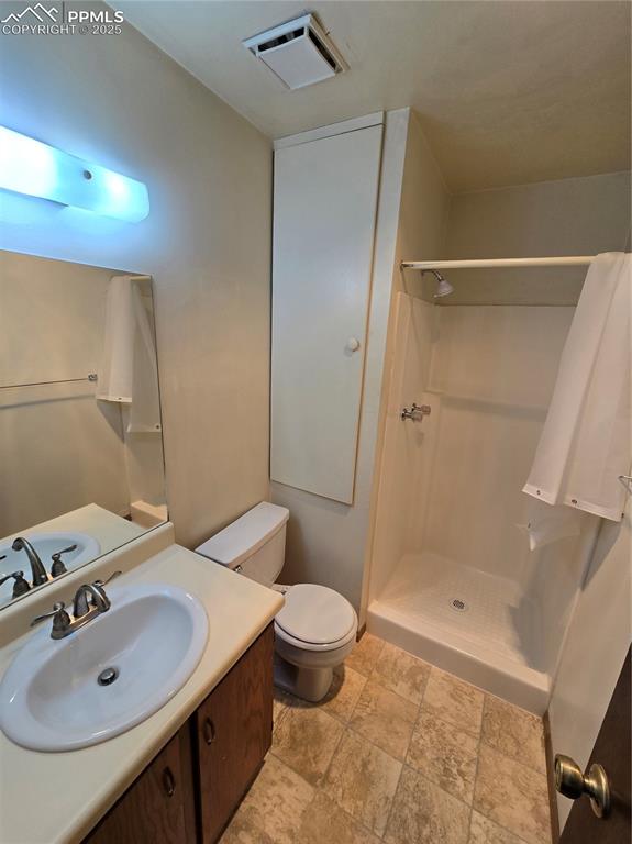 Image 18 of 21: Unfurnished bedroom with baseboard heating, multiple closets, a textured ce