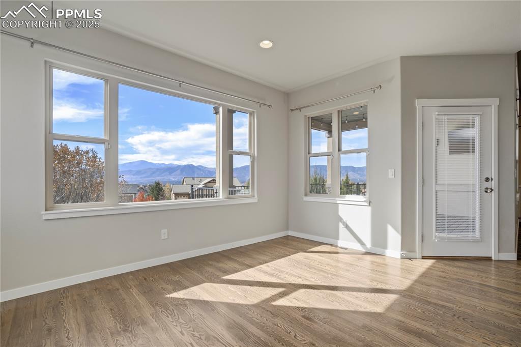 Image 10 of 50: Empty room featuring a mountain view, light wood-style floors, and recessed