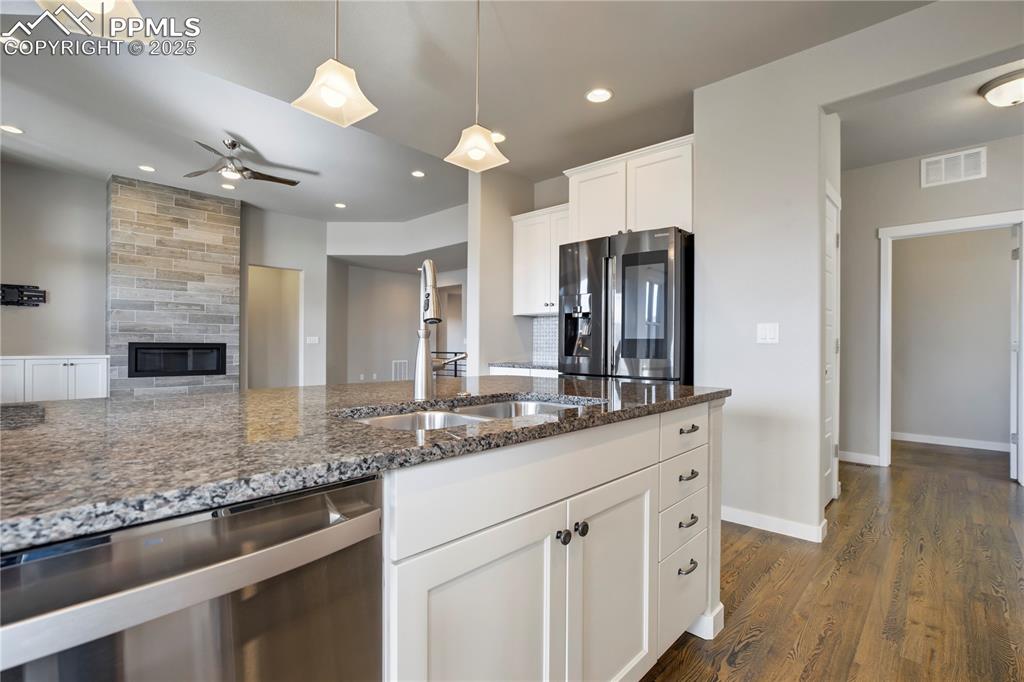 Image 12 of 50: Kitchen with appliances with stainless steel finishes, dark stone counterto