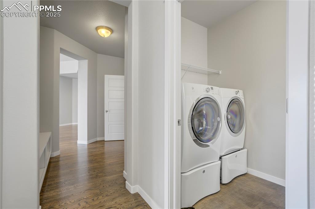 Image 18 of 50: Washroom with dark wood-style floors and separate washer and dryer