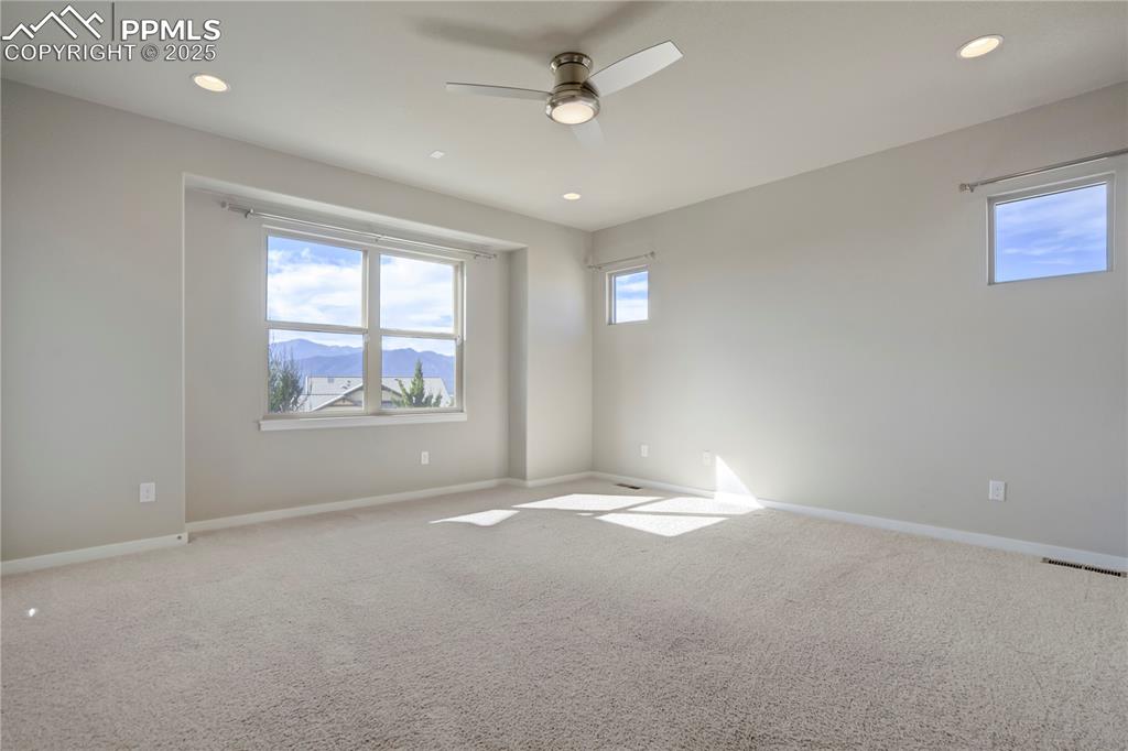 Image 19 of 50: Carpeted main level primary room featuring plenty of natural light, recesse