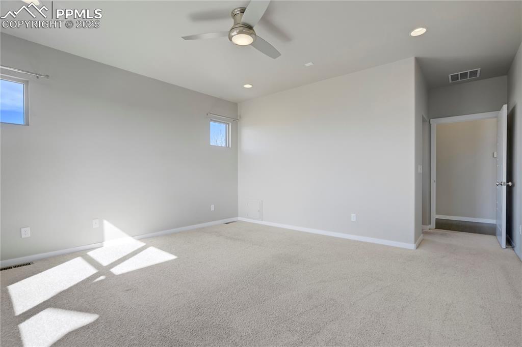 Image 20 of 50: Primary Room with recessed lighting, light carpet, and ceiling fan