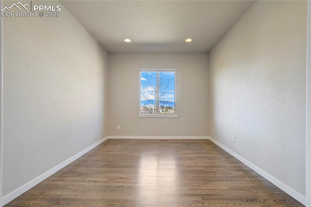 Image 28 of 50: room with dark wood-style flooring, recessed lighting, and a textured wall