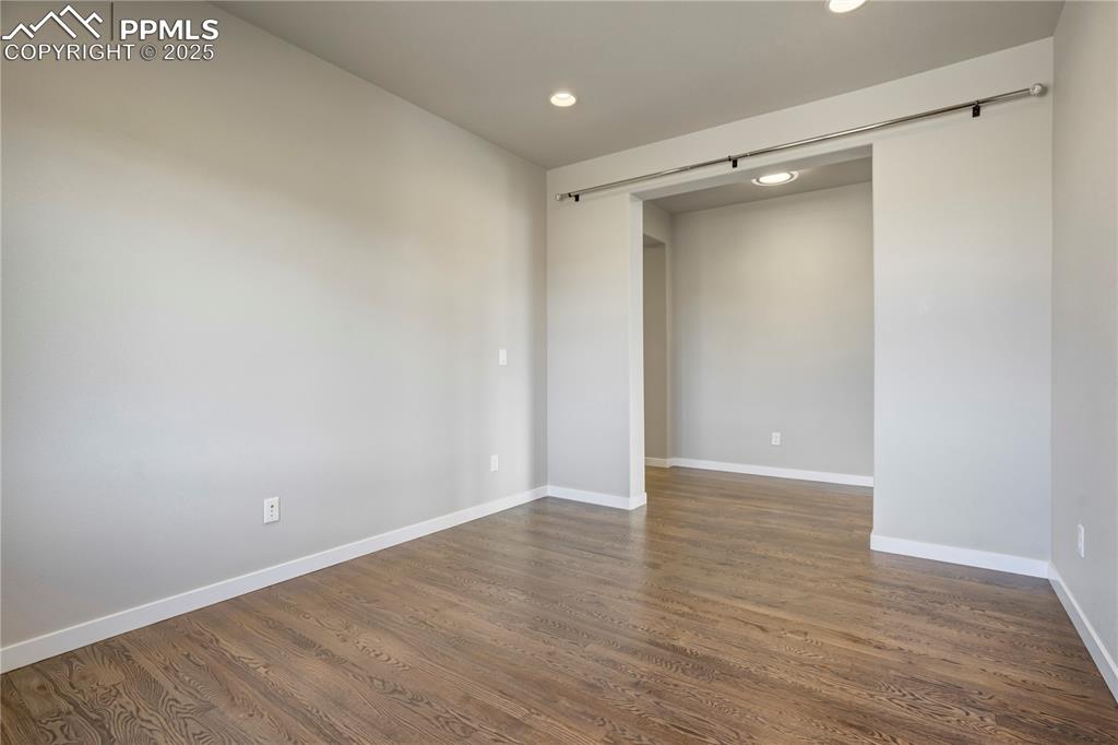 Image 29 of 50: room with recessed lighting and dark wood-style flooring