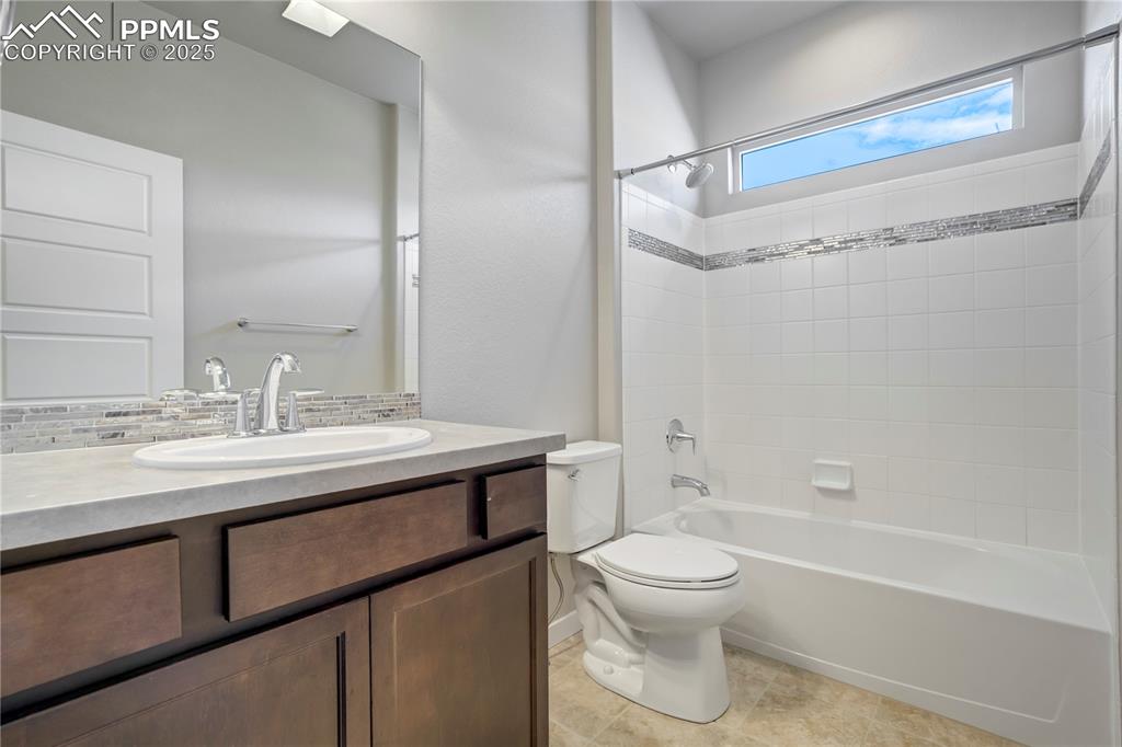 Image 32 of 50: main level guest Full bath featuring tub / shower combination, vanity, ligh