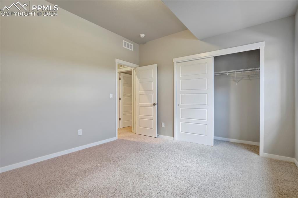 Image 38 of 50: bedroom featuring light carpet and a closet