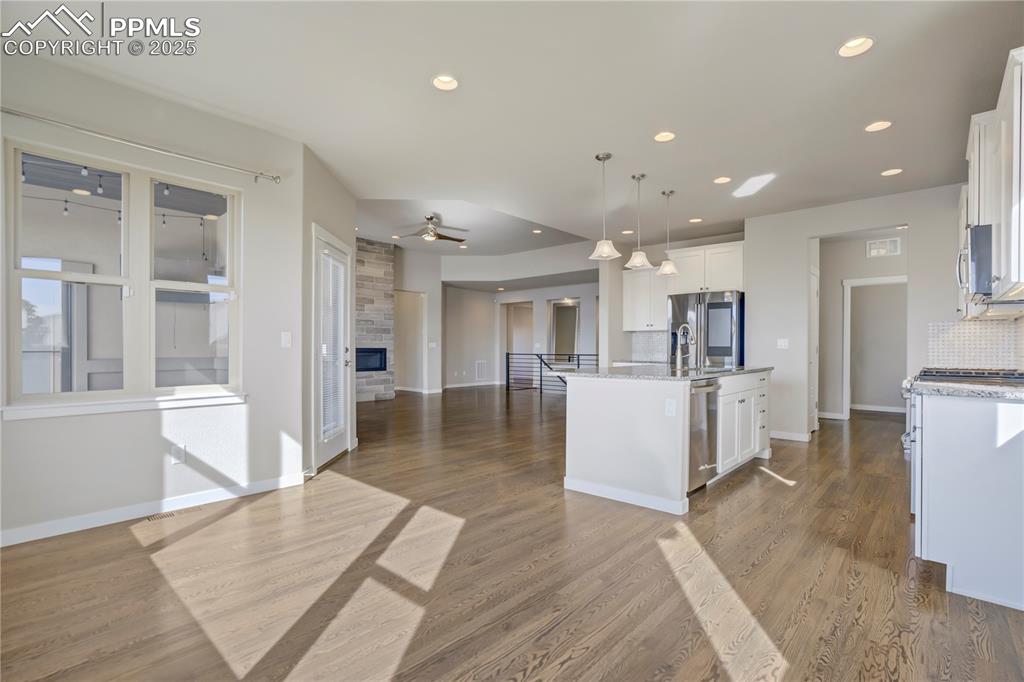Image 9 of 50: Kitchen with pendant lighting, a fireplace, open floor plan, tasteful backs